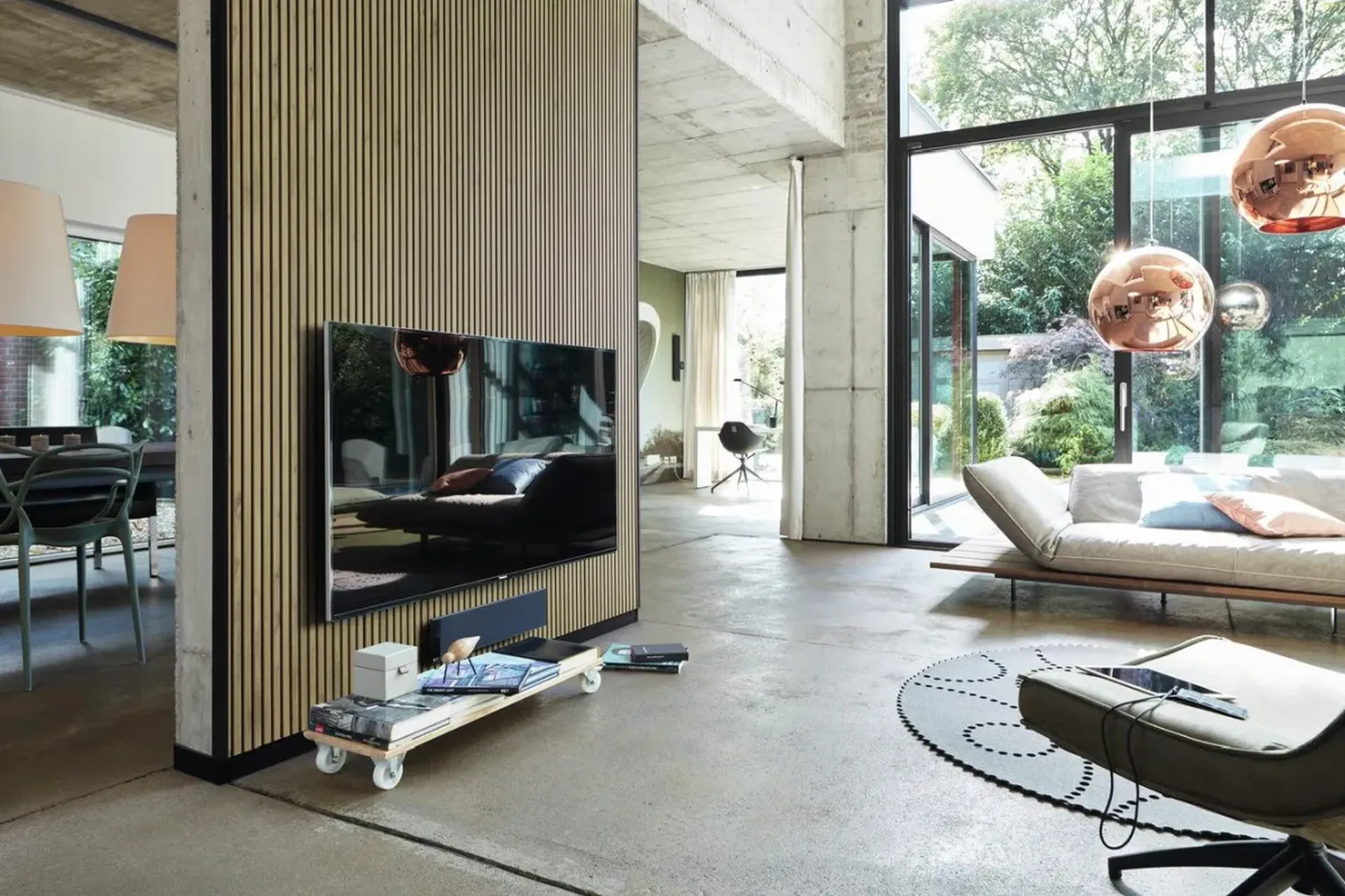 Akustikpaneele aus Holz im modernen Wohnraum mit TV-Wand und großen Fenstern