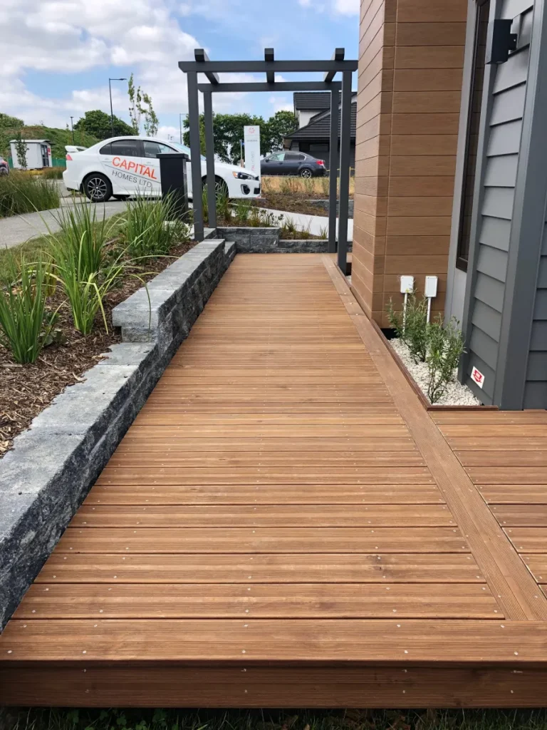 Holzterrasse mit Vulcan Decking von Abodo Wood als Zugang neben einem modernen Wohnhaus
