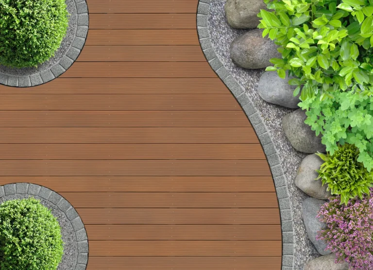 Geschwungene Holzterrasse aus Bangkirai zwischen Beeten und Gartenpflanzen